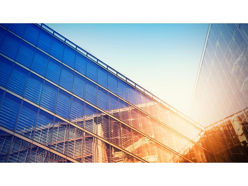 Modern building bathed in evening sunlight, reflecting against the glass.