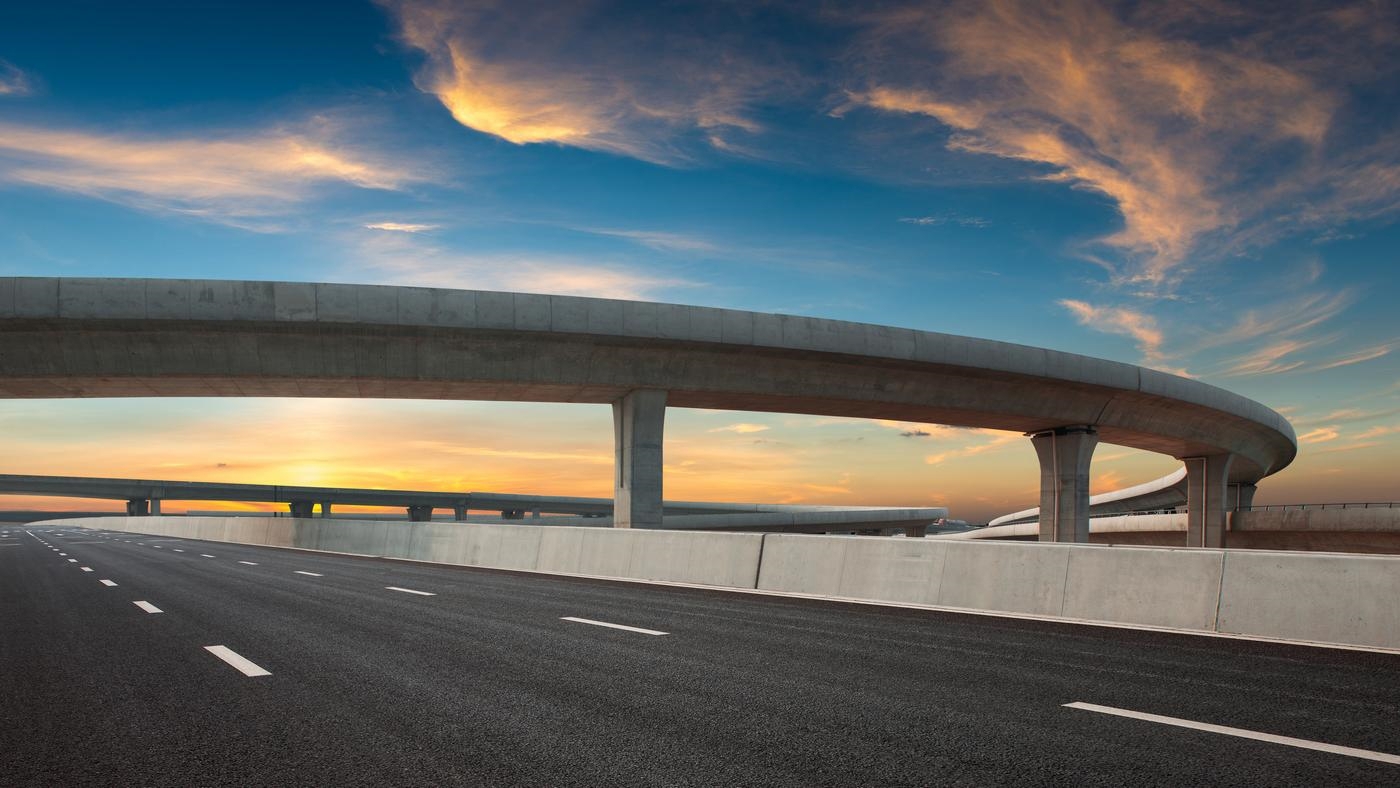 Asphalt road of a crossover overpass under a clear sky in the evening.