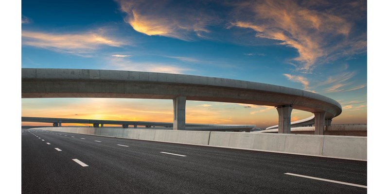 Asphalt road of a crossover overpass under a clear sky in the evening.