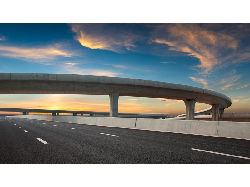 Asphalt road of a crossover overpass under a clear sky in the evening.