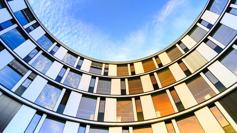Inward curved glass facade of a modern office building in Hamburg, Germany.