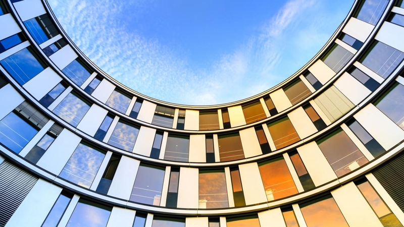 Inward curved glass facade of a modern office building in Hamburg, Germany.