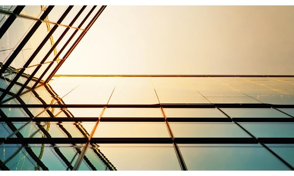 Modern angled corporate building,  the sunlight reflecting against the glass.