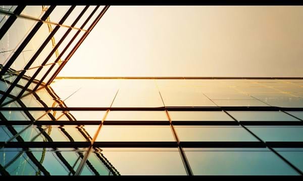 Modern angled corporate building,  the sunlight reflecting against the glass.