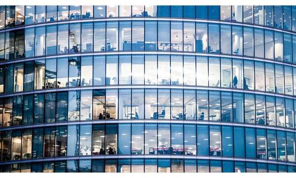 A curved glass office building, with interiors visible.  London, UK.