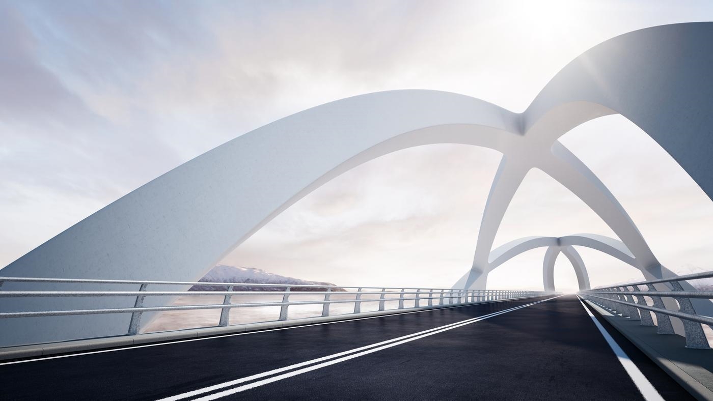 Modern curved architectural white bridge, against a backdrop of a river and mountain landscape on the left.