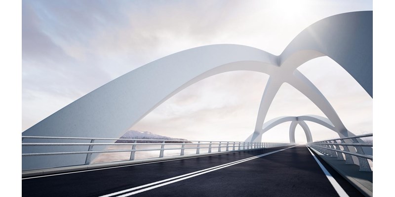 Modern curved architectural white bridge, against a backdrop of a river and mountain landscape on the left.