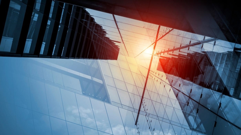 Skyscraper or modern building in the city with sunlight reflecting on the glass facade.
