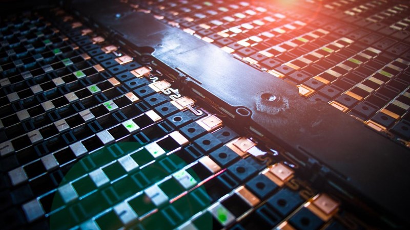 A close-up of a computer rack or electric vehicle battery, with a light shining on it.