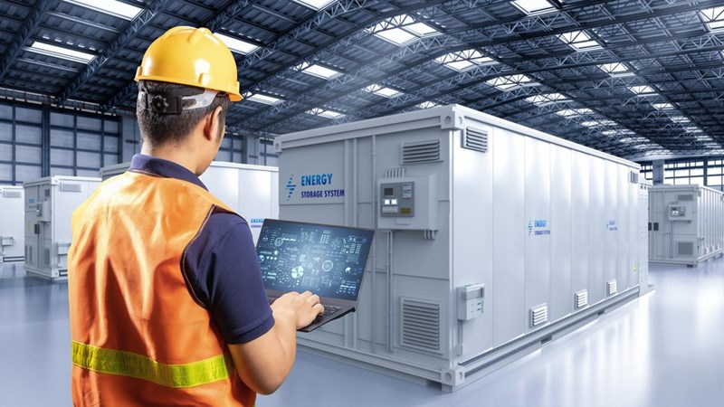 Engineer controlling energy storage system or battery container unit in factory.