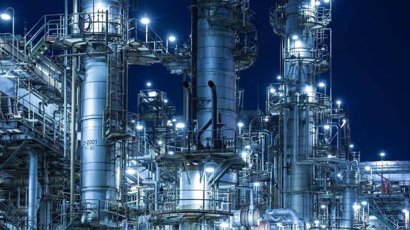 An illuminated gas/oil refinery at night. 