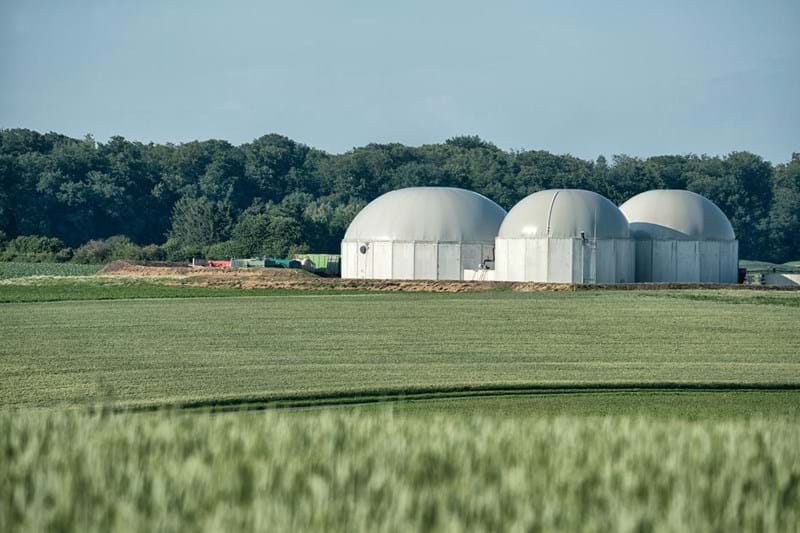 Biomass energy plant in a rural landscape on a hot summer day .