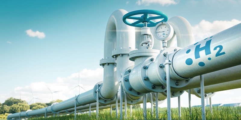 3D render of hydrogen pipelines in a field with wind turbines in the distance.