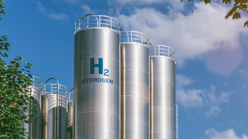 Several hydrogen fuel storage cylinders, against a blue sky.