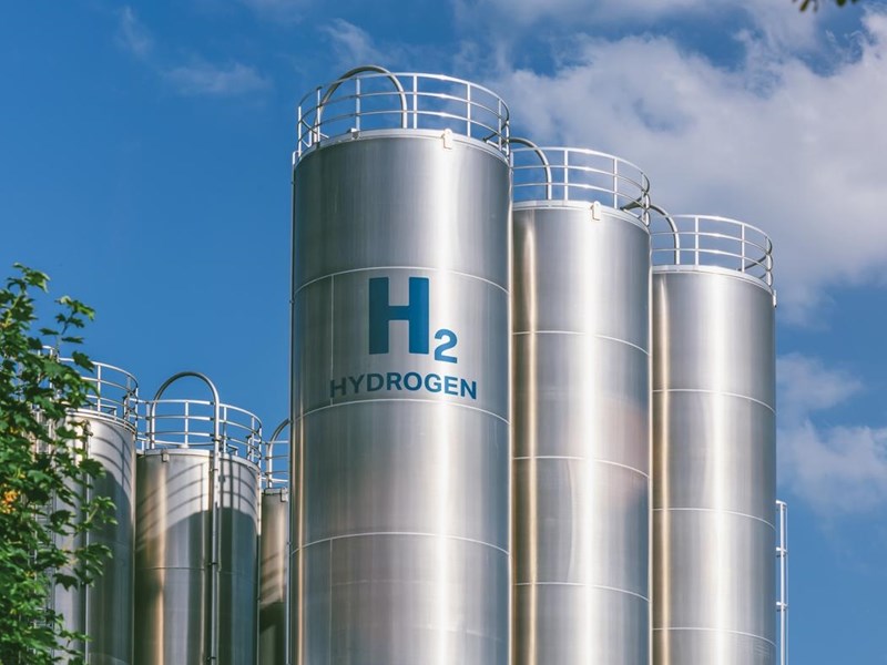 Several hydrogen fuel storage cylinders, against a blue sky.
