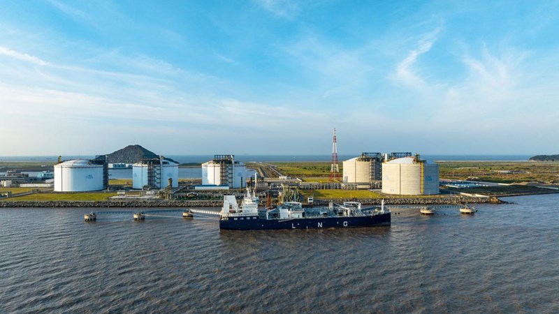 Drone Aerial view Oil ship tanker load or unload oil at loading dock from Large Tank warehouse with Terminal commercial port and cityscape background for transportation on the sea.