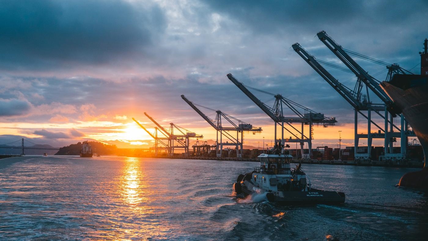 OA container ship leaving an empty port at dusk.