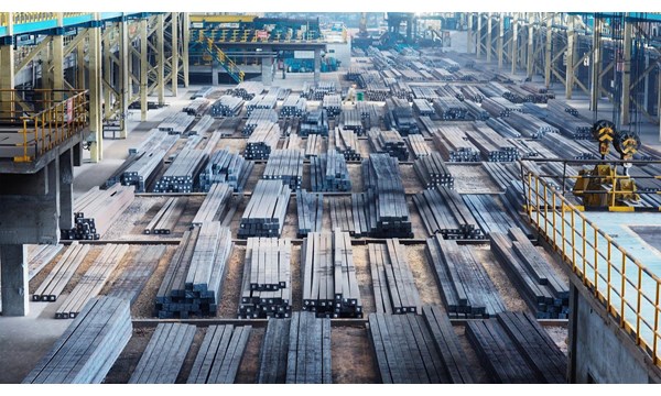 A large open factory with vast amounts of steel beams lined up.