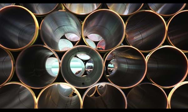 Stacked rows of metallic tubes.