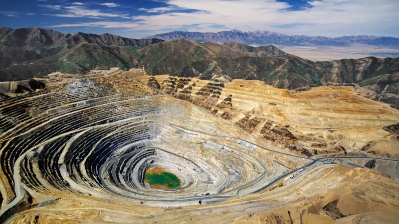 A large quarry pit in the middle of a mountain range.