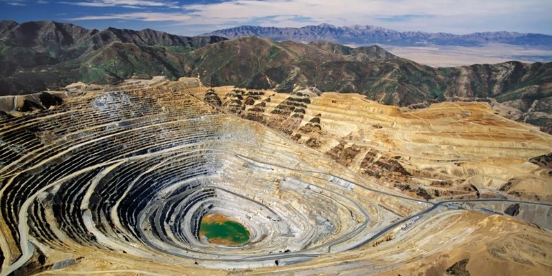 A large quarry pit in the middle of a mountain range.