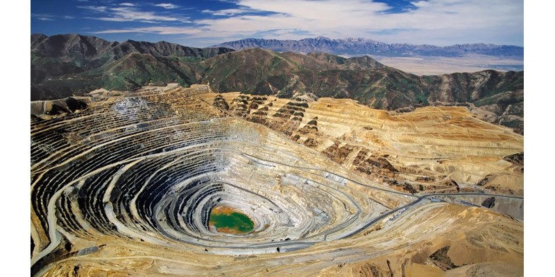 A large quarry pit in the middle of a mountain range.