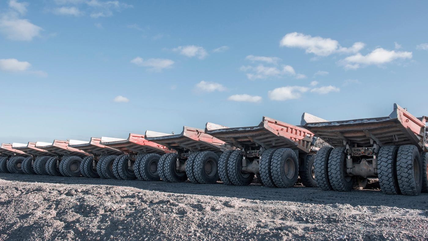The rear of dump trucks lined up in a row.
