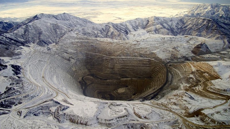 A vast, deep quarry in the middle of a mountain range.