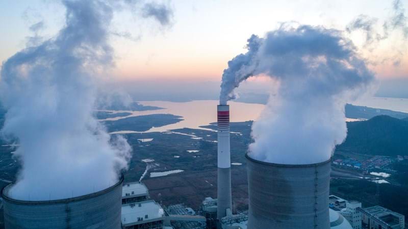 Modern power-plant producing steam from the nuclear cooling towers. Smoke coming from refining chimney stack.