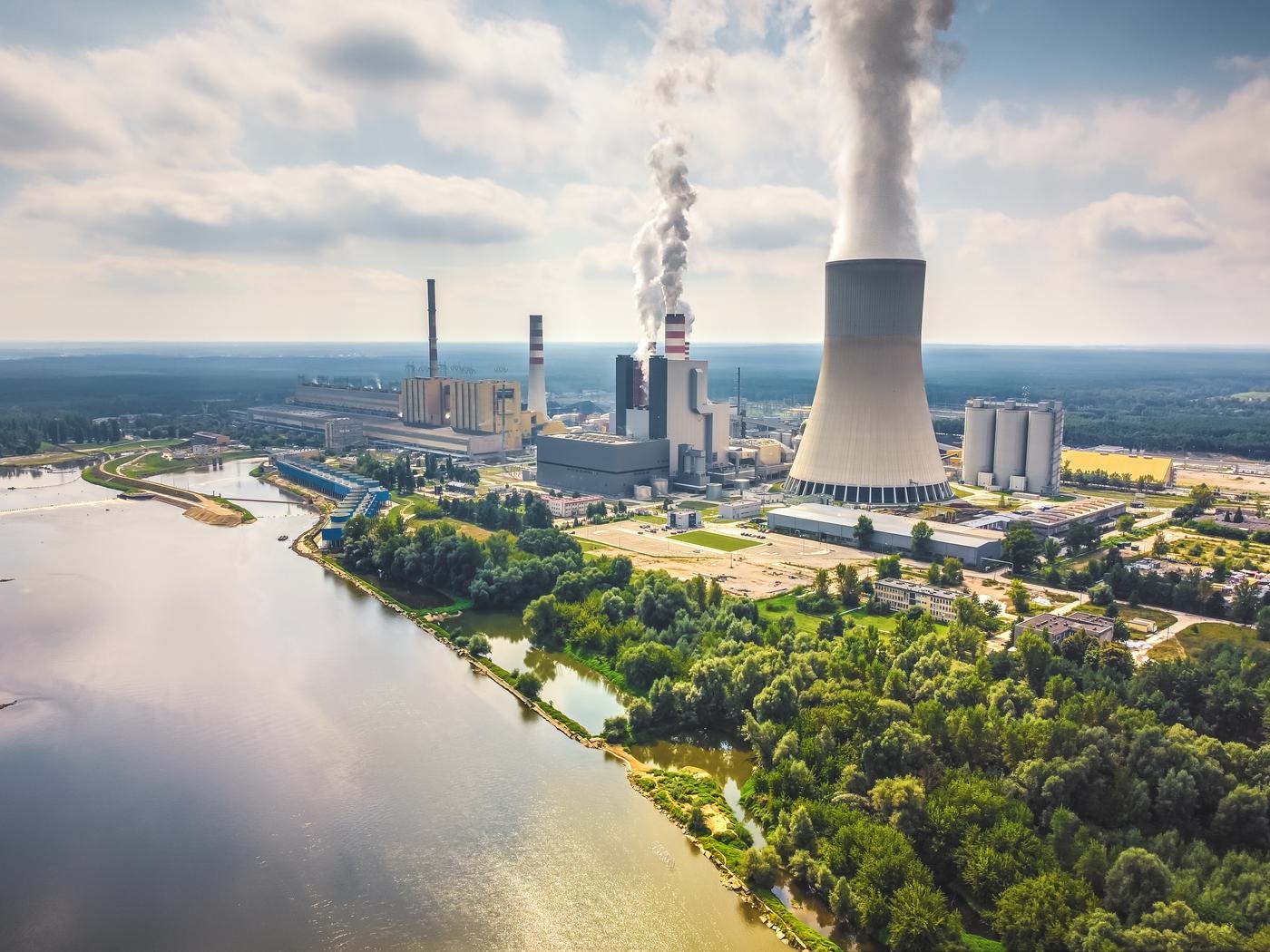 Large nuclear power station with steam coming from cooling tower. Drone, aerial view