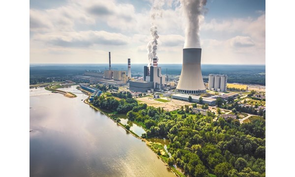 Large nuclear power station with steam coming from cooling tower. Drone, aerial view