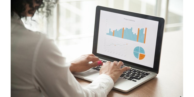 Businesswoman analysing statistics on laptop screen, working with financial graphs charts online, using business software for data analysis and project management concept, rear close up view