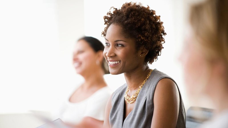 A group of smiling businesswomen in a meeting.