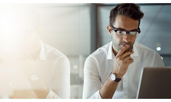 Cropped shot of a young businessman, looking thoughtful while working on his laptop in the office.