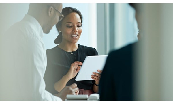Business people working in high-end modern office, a woman is using her iPad and smiling.