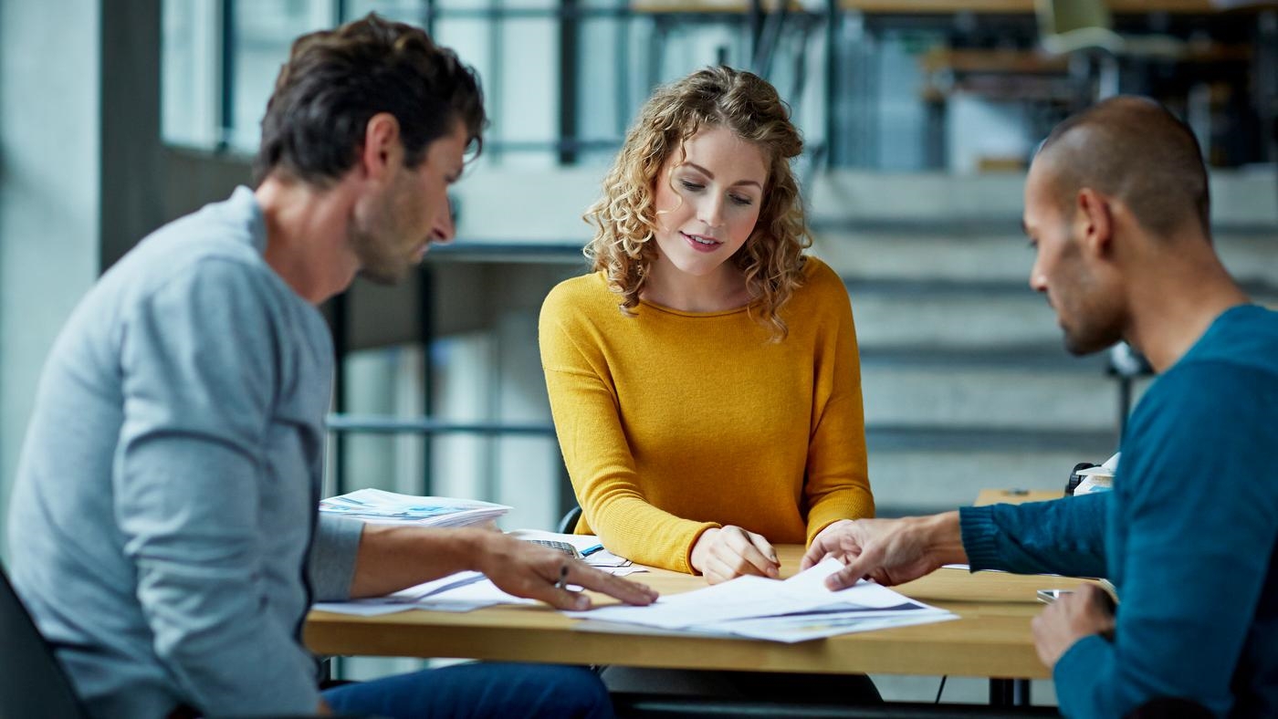 Coworkers working on project at table in modern studio