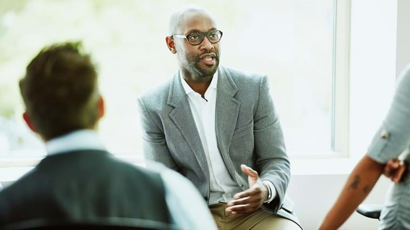 Businessman leading team informal team meeting in office.