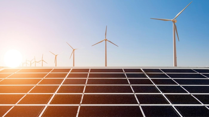Solar panels and wind turbines on a sunny day.