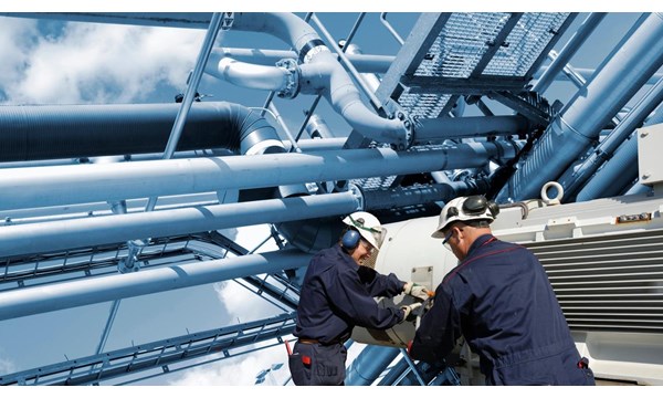 Two oil and gas workers with large fuel pipelines.