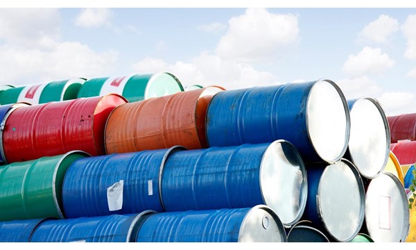 Stacked rows of red, green, blue and yellow oil drums.