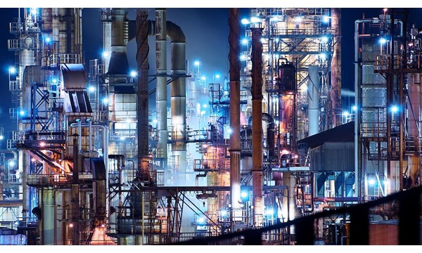 Vast illuminated refinery at night.