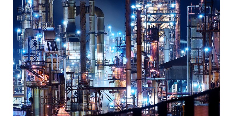 Vast illuminated refinery at night.