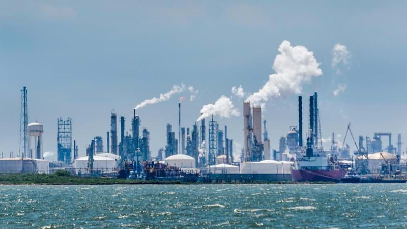 Atmospheric distortion blurs the view of the petrochemical oil processing refinery plant of the industrial skyline in Texas City, Texas, USA, on Galveston Bay and the Gulf of Mexico