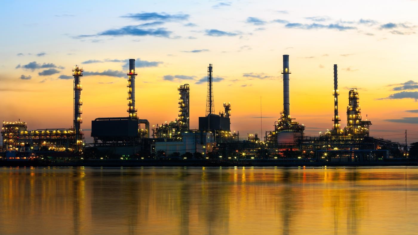 Refinery plant area at twilight with reflection in river