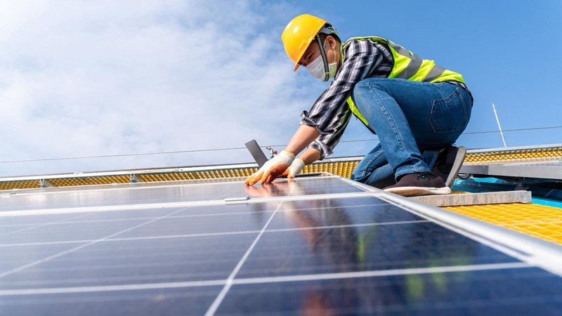 An engineer installing solar panels on a roof.