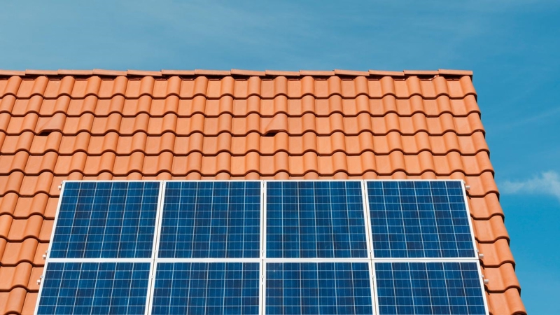 Solar panels on the pitched tiled roof of a house.
