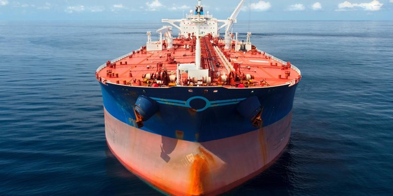 A close-up of a large red and blue oil tanker in the ocean.