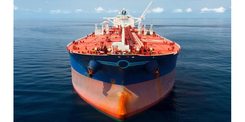 A close-up of a large red and blue oil tanker in the ocean.