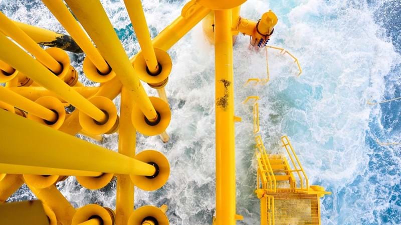 A close-up aerial view of an oil rig in the ocean.