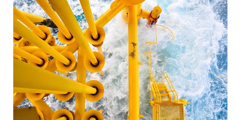 A close-up aerial view of an oil rig in the ocean.